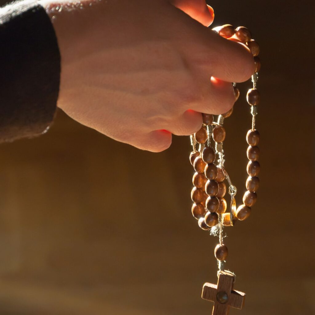 Hands praying a rosary